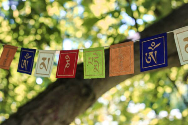 Ręcznie malowane flagi, girlandy z nepalskiego papieru czerpanego lokta. Motyw mantry om mani padme hum. Kolorowe ze złotymi znakami.